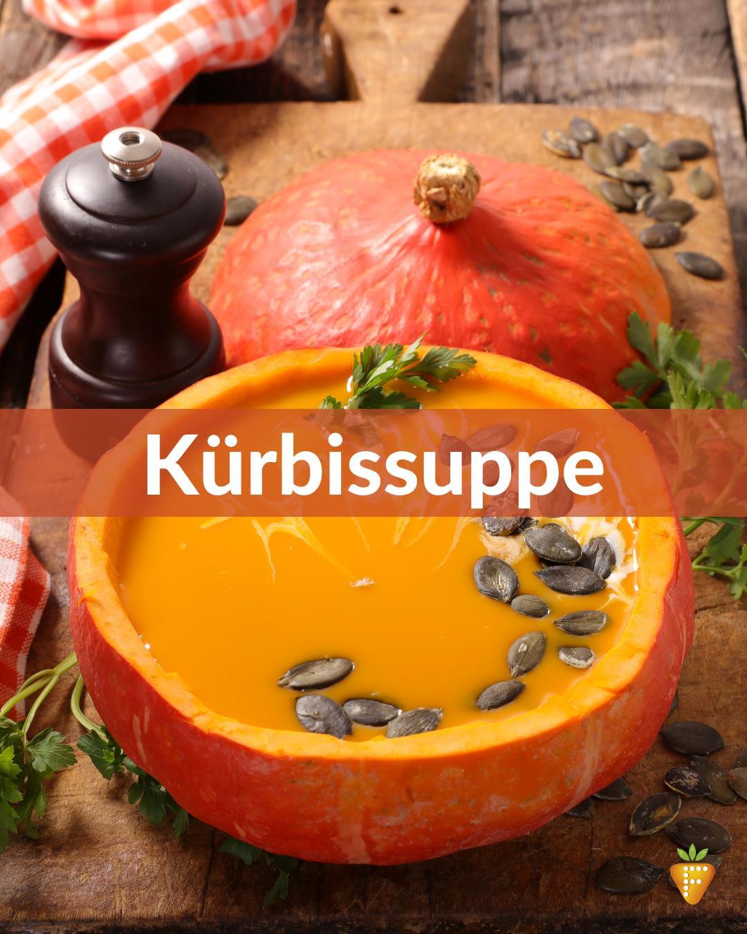 Kürbissuppe serviert in einem ausgehöhlten Kürbis, garniert mit Kürbiskernen.