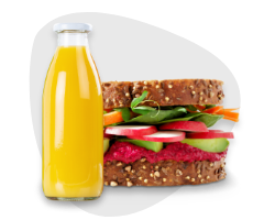 Frisches Vollkorn-Sandwich mit Gemüse und Aufstrich, dazu eine Flasche Orangensaft – Teil des Convenience- und Feinkostsortiments im Foodservice von Frucht Hartmann.