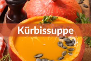 Kürbissuppe serviert in einem ausgehöhlten Kürbis, garniert mit Kürbiskernen.